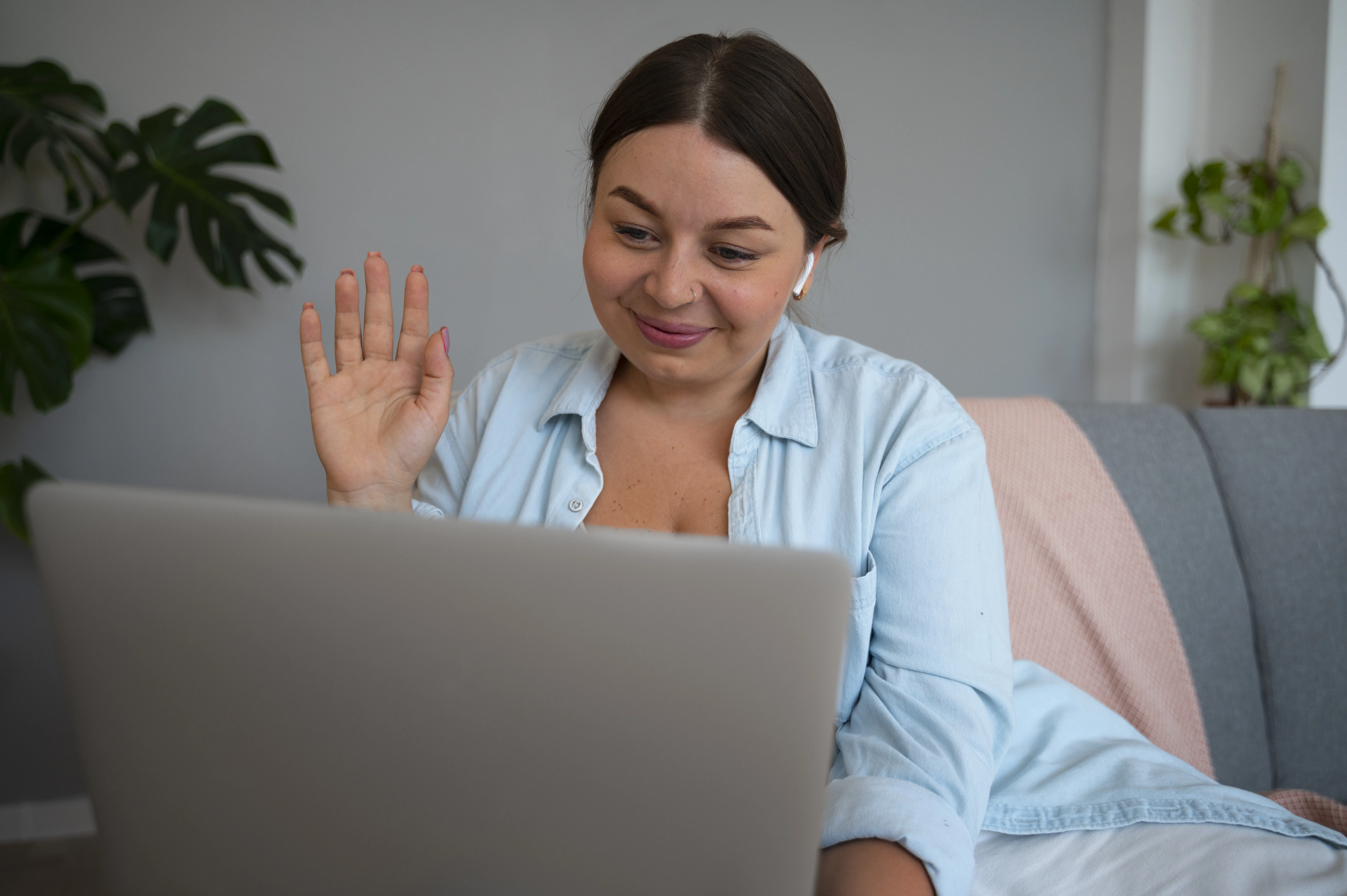 desarrolladora en su onboarding – Giga IT Desarrolladora trabajando en su computadora y saludando durante su primera semana de onboarding remoto